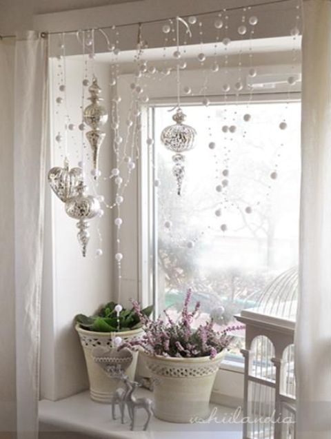 refined vintage Christmas window styling with beads, rhinestones, silver ornaments and a cage and some blooms on the windowsill