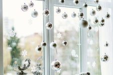 silver and white ornaments, snowflakes and deer will isntantly make your window look like Christmas