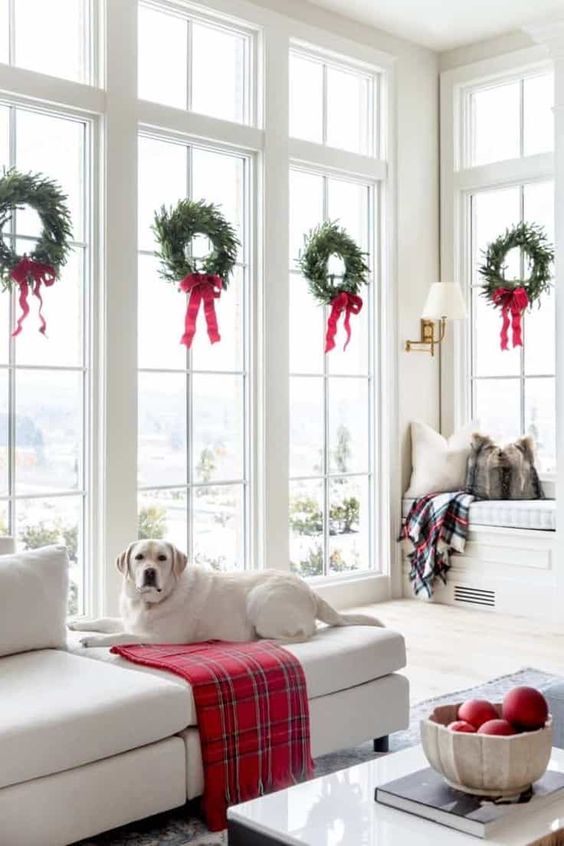 small Christmas wreaths with red bows will style your window in a cool holiday way and will make it chic