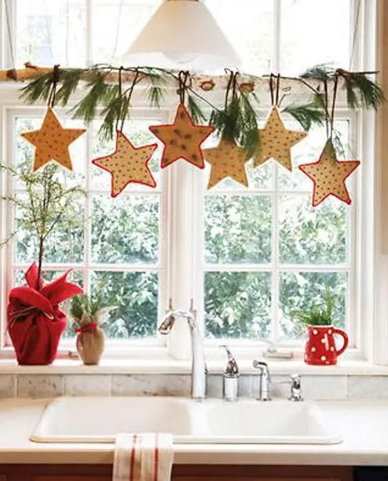 Star shaped cookies, evergreens on a branch are a cool way to style a window for Christmas