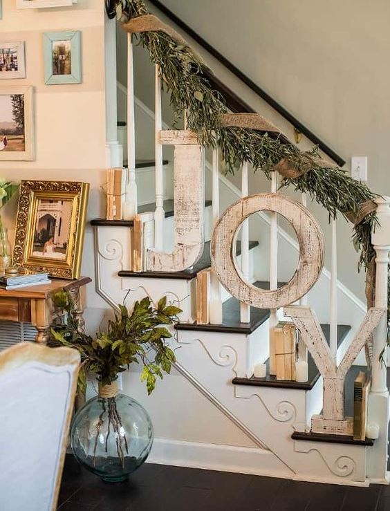 vintage Christmas stairs decor with vintage books, candles, wooden letters, fir branches and burlap ribbon feels rustic and cozy