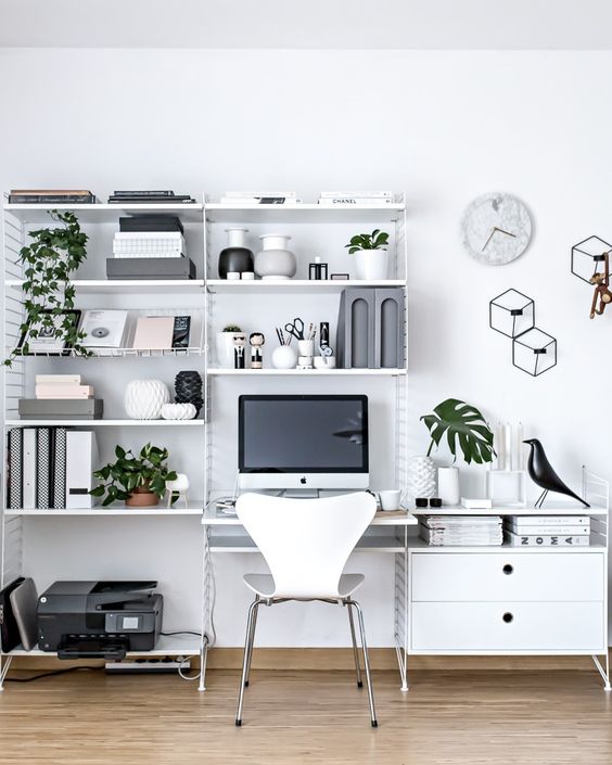 a Nordic home office with a large metal storage unit with open shelves, a desk and a sideboard that are integrated into this system