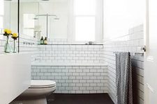 a Scandinavian bathroom in black and white, with natural wood and printed towels