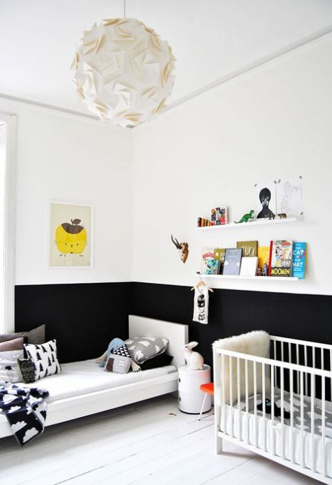 a Scandinavian kid’s room with color block walls, a couple of beds, some ledges for books and colorful books