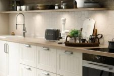 a Scandinavian one wall ktichen with a hex tile backsplash, vintage cabinets, open shelves and a wooden backsplash is chic