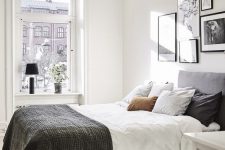 a catchy Scandinavian bedroom with a grey bed and monochromatic bedding, a gallery wall, a pendant lamp and some decor
