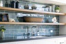a chic kitchen with white cabinetry, open shelves, a blue tile backsplash is a chic farmhouse space with a touch of coastal decor