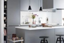 a contemporary Scandinavian kitchen with sleek grey cabinetry, white countertops and a backsplash, black pendant lamps and stools