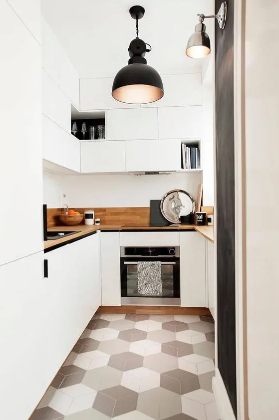 a contemporary white kitchen with sleek cabinetry, light stained countertops and a geometric tile floor