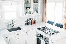 a contemporary white kitchen with white countertops and a backsplash is a small and cozy space