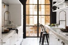 a contrastign galley kitchen with metal cabinets, an arched window, a dining zone by the window and greenery