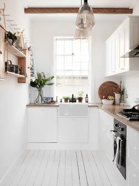 A cool L shaped Scandinavian kitchen with butcherblock countertops, open shelves and wooden beams
