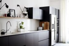 a cool Scandinavian kitchen with matte black cabinets, white countertops and a backsplash, an open shelf and black and white tiles on the floor