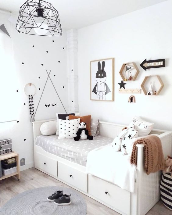 a cute Nordic kid's room with a bed with storage, a small nightstand, a gallery wall with shelves and artworks and a printed wall