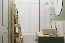 a green Scandinavian bathroom with green walls and skinny tiles, a bathtub, a green vanity, a mirror, a black pendant lamp