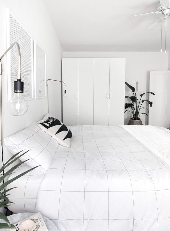 a minimalist meets Nordic bedroom with sleek storage units, a bed, some bulbs and artworks