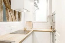 a minimalist white L-shaped kitchen with butcherblock countertops and wooden beams looks very cool