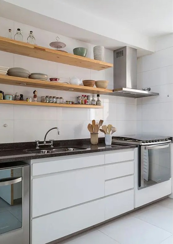 a minimalist white kitchen with black stone countertops and open shelves is a chic and elegant idea
