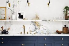 a navy one wall kitchen with a white stone backsplash and countertops, a stone shelf and sconces is super chic