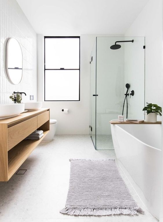 a neutral Scandinavian bathtroom with skinny tiles, a shower space, a tub, a stained vanity with sinks, black fixtures
