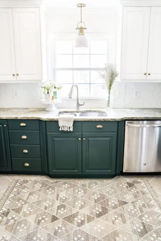 A one wall two tone kitchen in white and dark green, with stone countertops and a patterned tile backsplash.