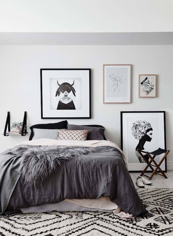 a pretty Scandinavian bedroom with a bed, catchy bedding, a printed rug, a gallery wall and a suspended shelf