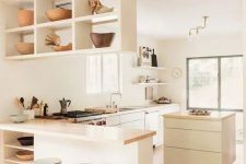 a pretty modern and neutral L-shaped kitchen with a suspended shelf, small kitchen island and butcherblock coutnertops