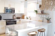 a refined U-shaped kitchen with white cabinetry, white stone countertops, wooden stools, open shelves and pendant lamps