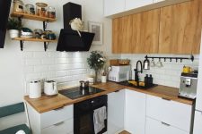 a small L-shaped white kitchen with butcherblock countertops and MDF cabinets, a white subway tile backsplash and black appliances