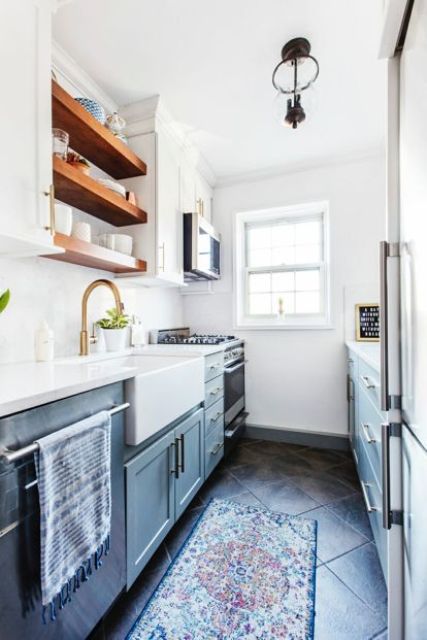 a small blue gallery kitchen with open shelves, built in appliances and a bold boho rug is a cozy and functional space