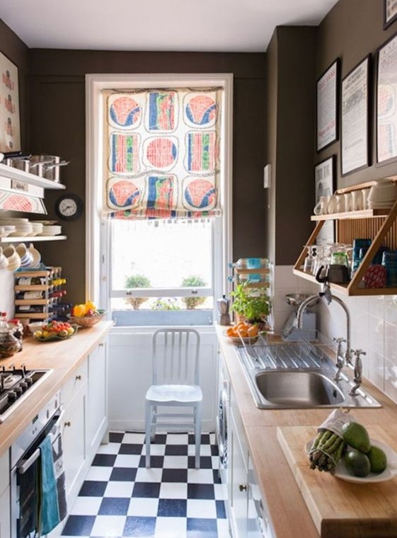 a small monochromatic kitchen with black walls, a white subway tile backsplash, butcherblock countertops and a colorful shade
