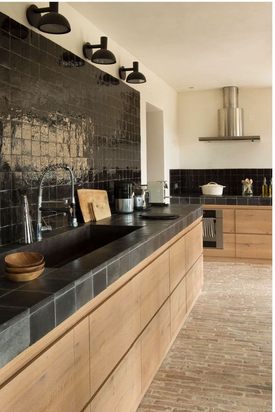 a stained kitchen with black tiles and a glossy black Zellige tile backsplash plus sconces is an amazing space