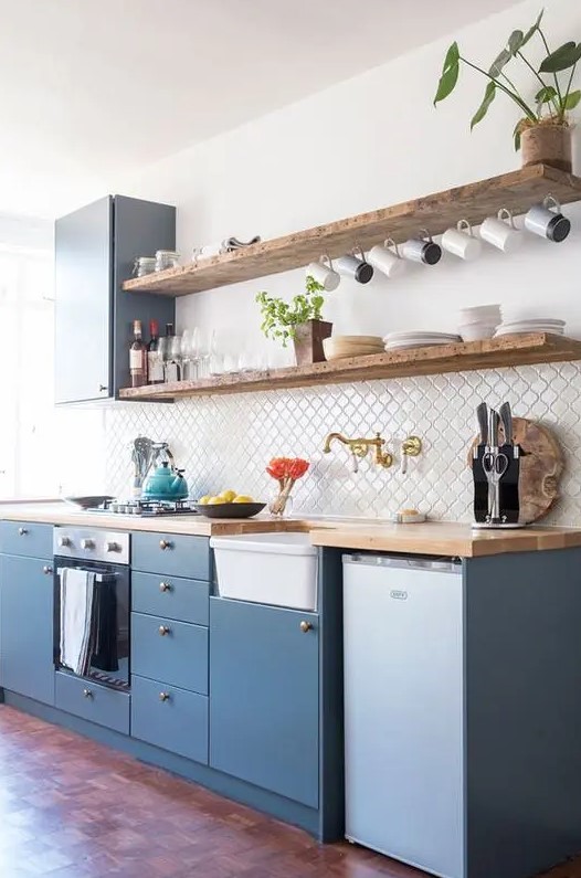a stylish blue one wall kitchen with a white Moroccan tile backsplash and butcherblock coutnertops is very chic