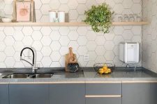 a stylish graphite grey one wall kitchen with a white hex tile backsplash and open blonde wood shelves