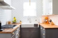 a stylish mid-century modern kitchen with grey lower cabinets and upper white ones, butcherblock countertops and white subway tiles