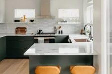 a stylish modern kitchen with graphite grey cabinets, white countertops, a white tile backsplash, amber leather stools