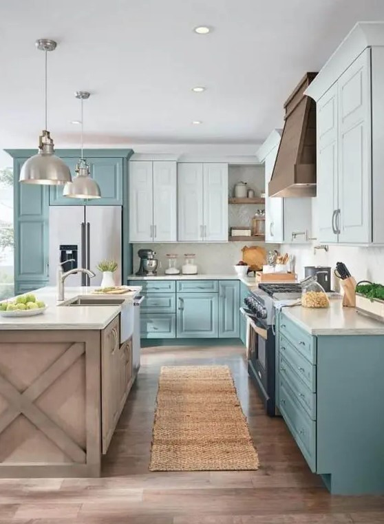 A two tone L shaped kitchen in turquoise and light blue, with a wooden kitchen island and pendant lamps