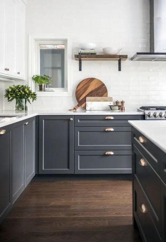 a two-tone kitchen with white and grey cabinets, a white tile backsplash and brass touches is very elegant