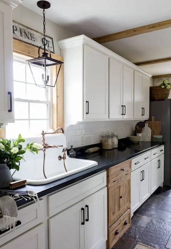 a vintage white one wall kitchen with a black coutnertop, a white subway tile backsplash and black fixtures is pure chic