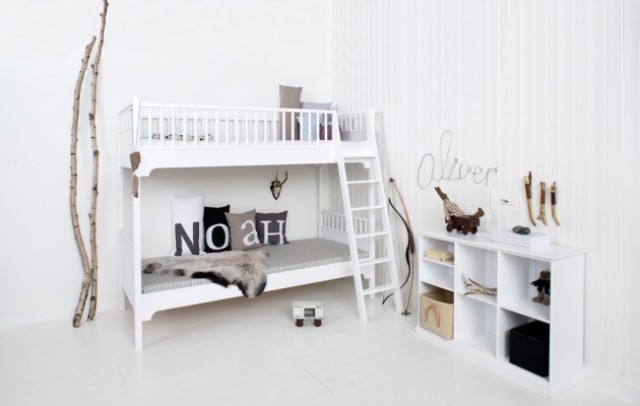 a white Scandinavian room with a bunk bed, a sideboard, some art, faux fur and branches and sticks used for decor