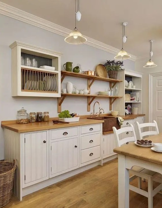 A white one wall farmhouse kitchen with butcherblock countertops, open shelves and box shelves is cozy.