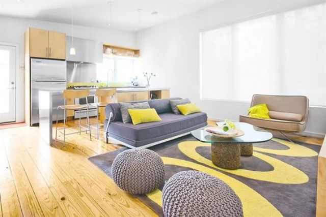 airy living room with grey and yellow details looks very cheerful, and yellowish wooden floors add a sunny touch