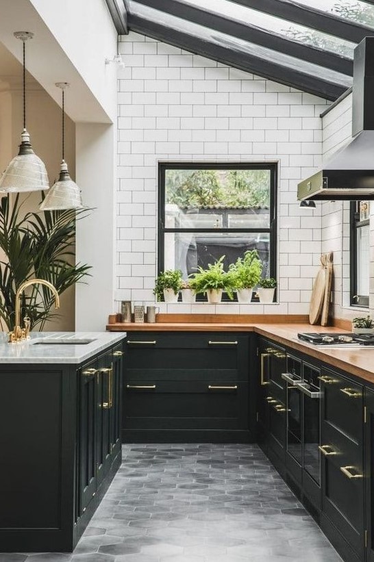 an elegant art deco kitchen in black, with butcherblock countertops, white subway tiles and a glazed ceiling