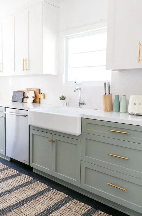 An ethereal two tone kitchen with a white backsplash and countertops, brass handles and a printed rug is super cool.