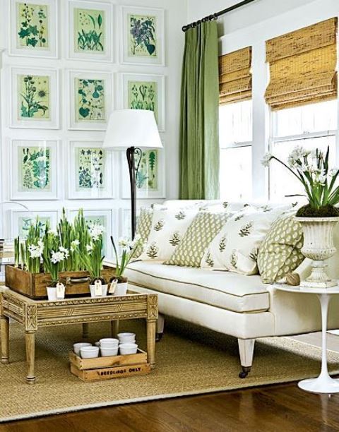 a lovely farmhouse living room with a gallery wall with botanical prints, some printed pillows, potted blooms and green curtains