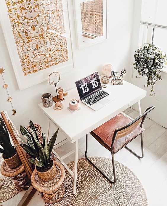 26 a neutral boho home office with pretty floral prints, a small desk and a leather chair, potted greenery and a rug is cozy and cute