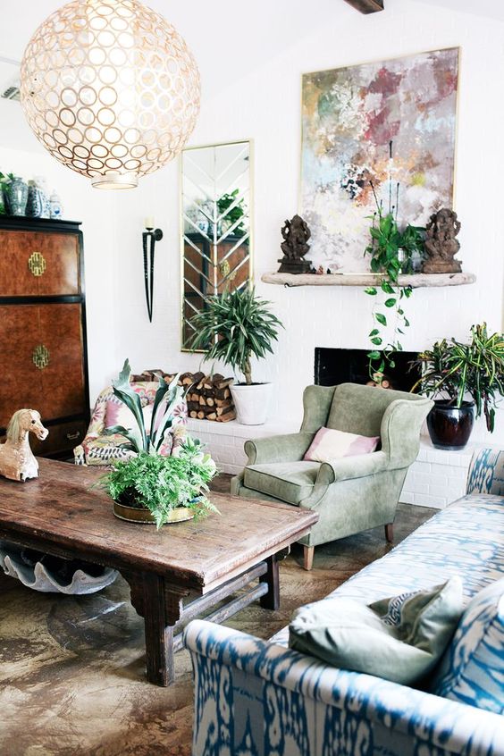 39 a bright eclectic living room with pastel living room, a fireplace, potted greenery and a sphere chandelier