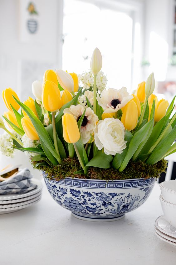 a chinoiserie bowl with moss and bright and white spring blooms is a pretty colorful centerpiece with a classic feel
