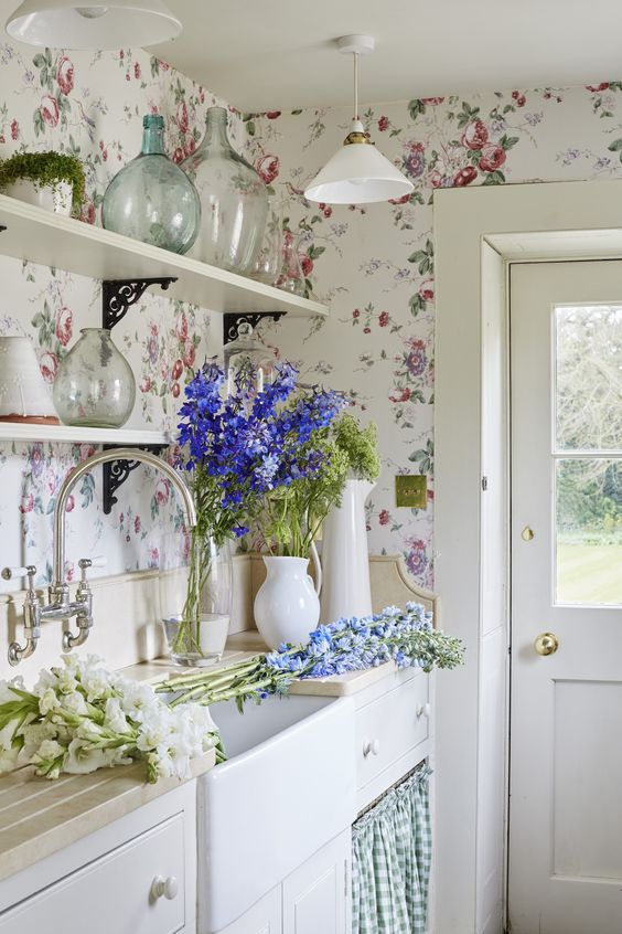 a vintage farmhouse kitchen in neutrals and with lovely pink and blue floral wallpaper that creates a mood here