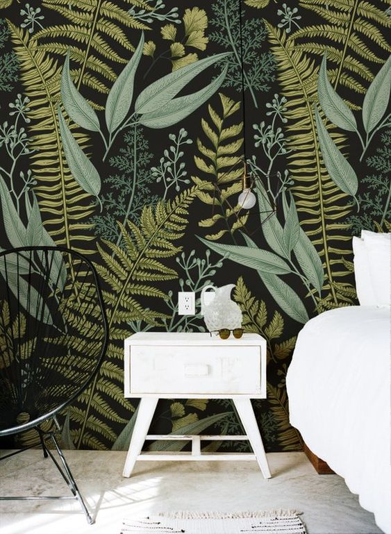 moody botanical print wallpaper is paired with black and white furniture to create a contrast and look outstanding
